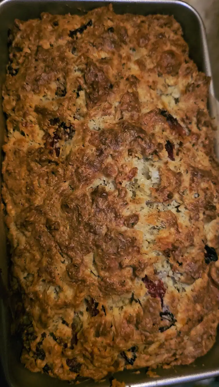 Herb and sundried tomato bread baked in a loaf pan.