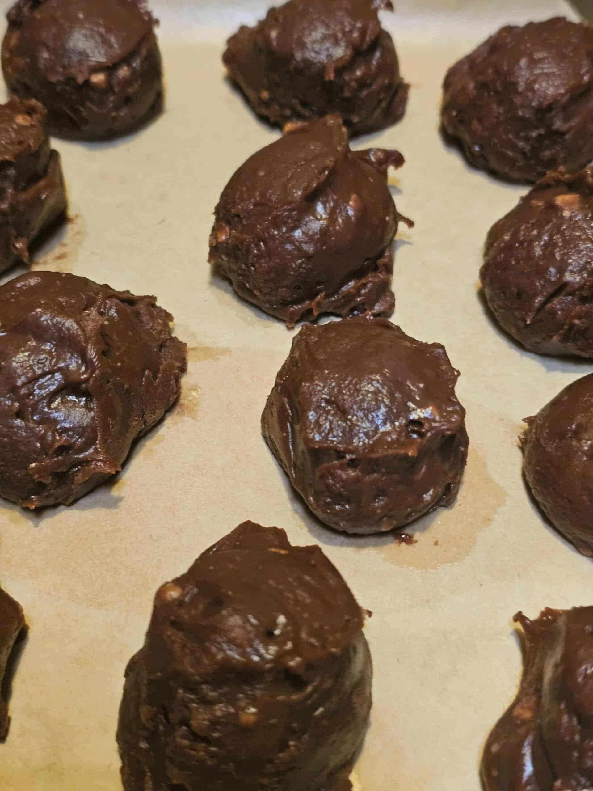 Chocolate hazelnut truffles on a pan before being coated in peanut butter topping