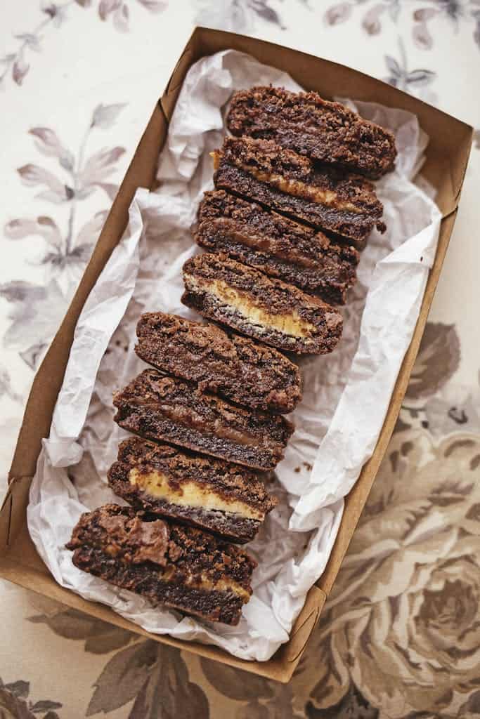 Sliced chocolate brownies arranged neatly in a decorative box, showcasing a tempting dessert presentation.