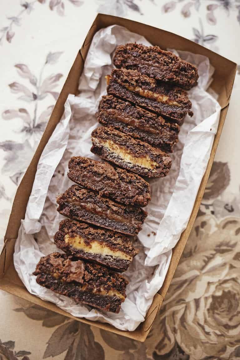 Sliced chocolate brownies arranged neatly in a decorative box, showcasing a tempting dessert presentation.