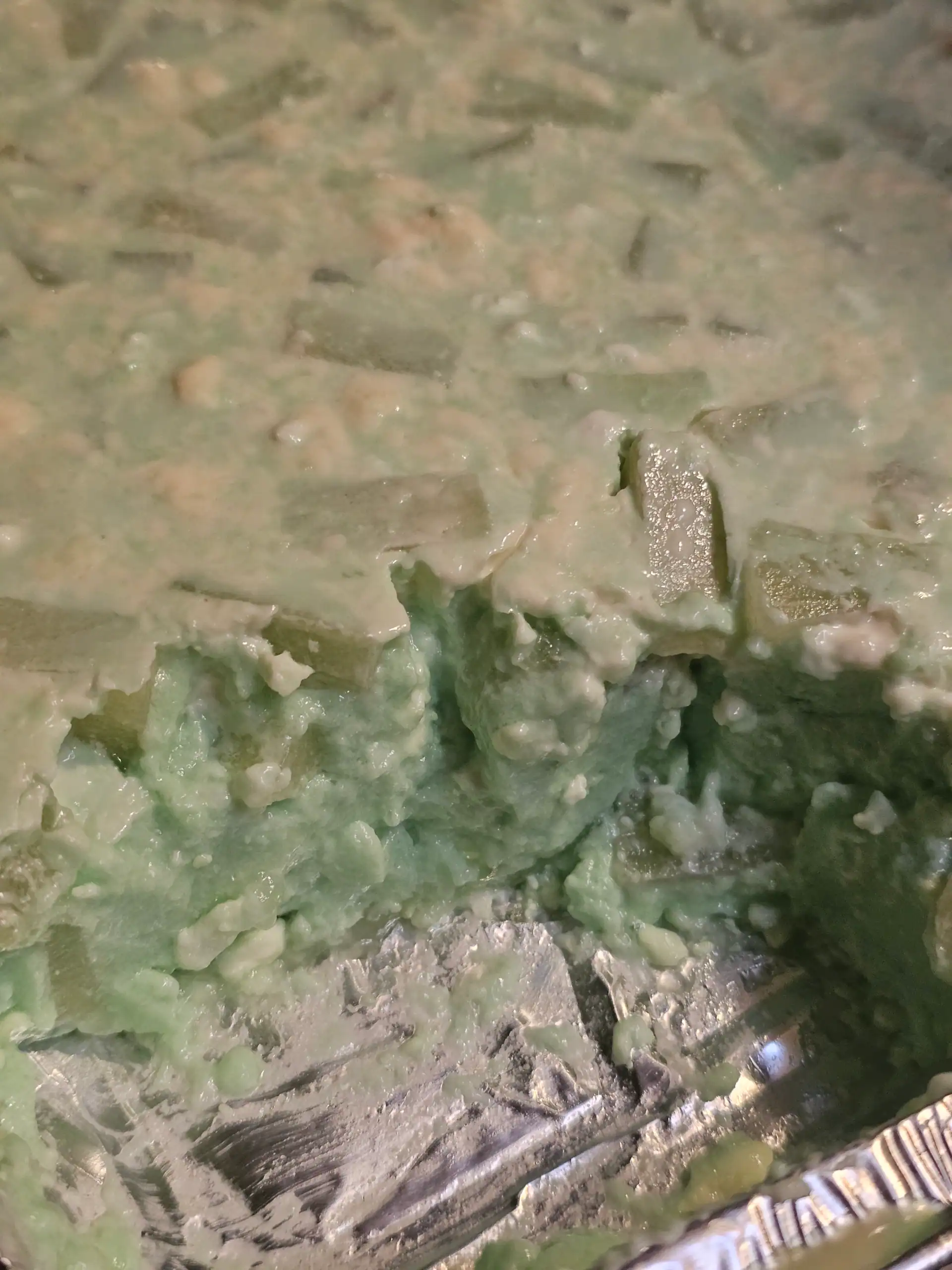 Green jello salad in tin with piece taken out